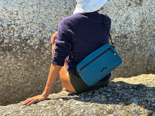 Anywhere Pouch in Teal slung across a woman 