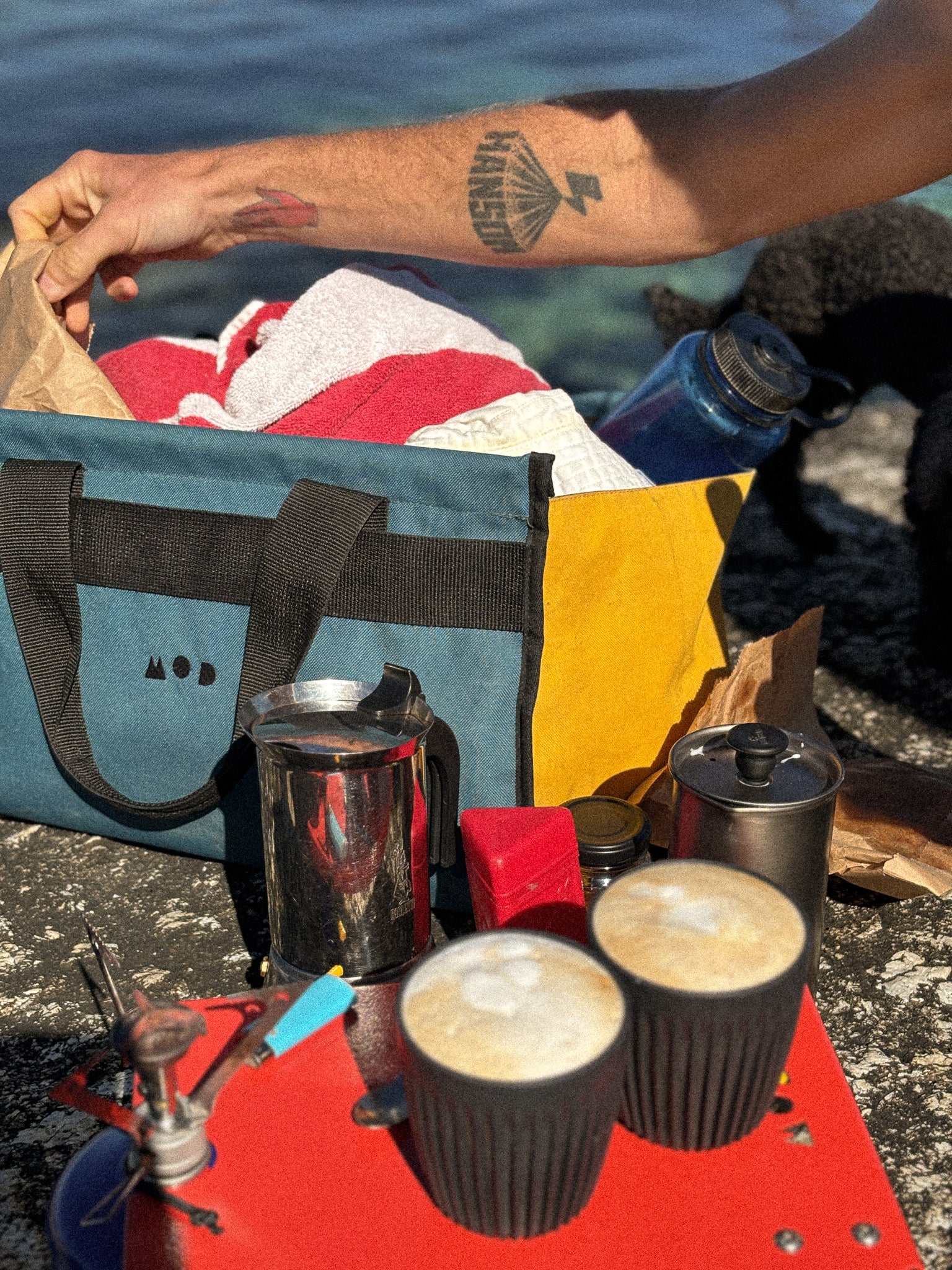 Cargo Tote in Teal and Yellow on the rocks at the beach with coffee